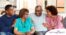 A couple sits with aging parents and enjoys their time together.